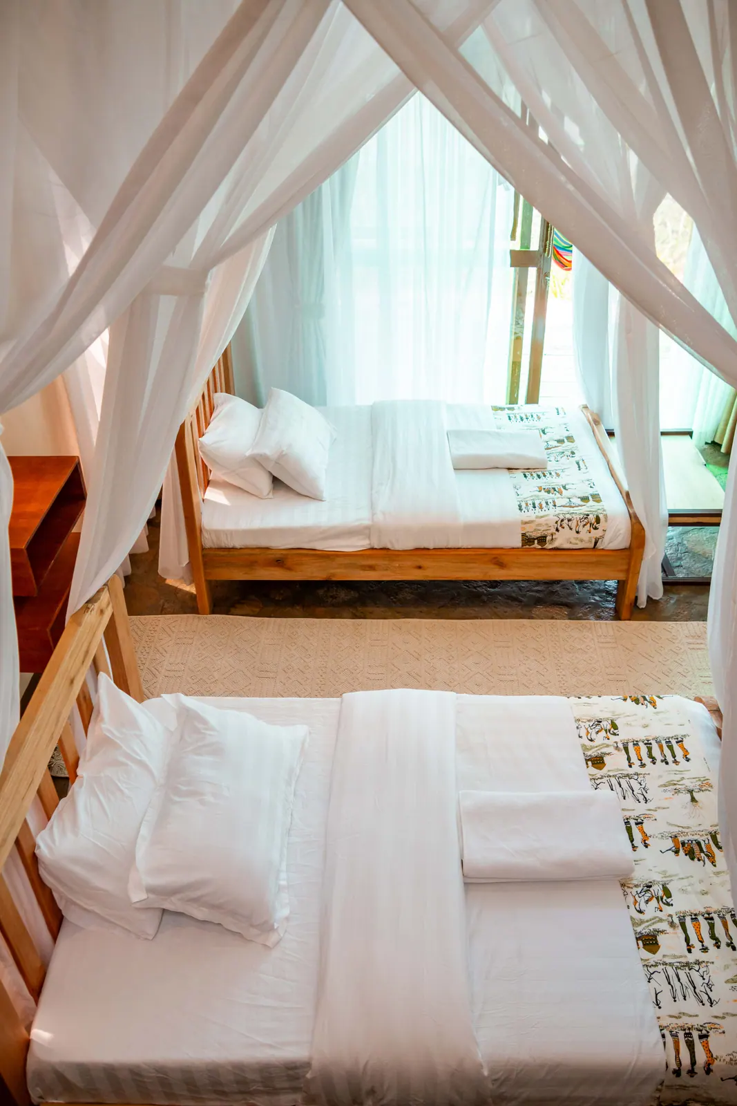 Twin guest room with two separate timber beds and mosquito nets